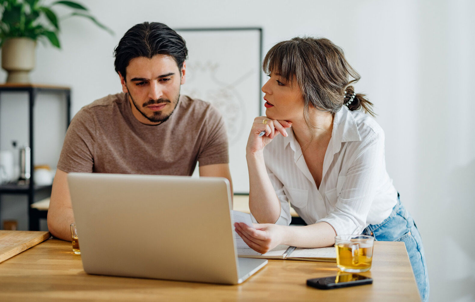 Two people in a discussion in front of a laptop